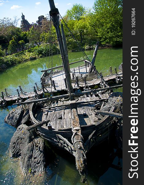 A shipwreck abandoned in a river, now being used to help support a walkbridge