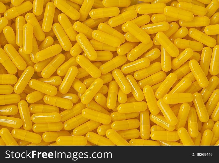 Many yellow capsule pills background