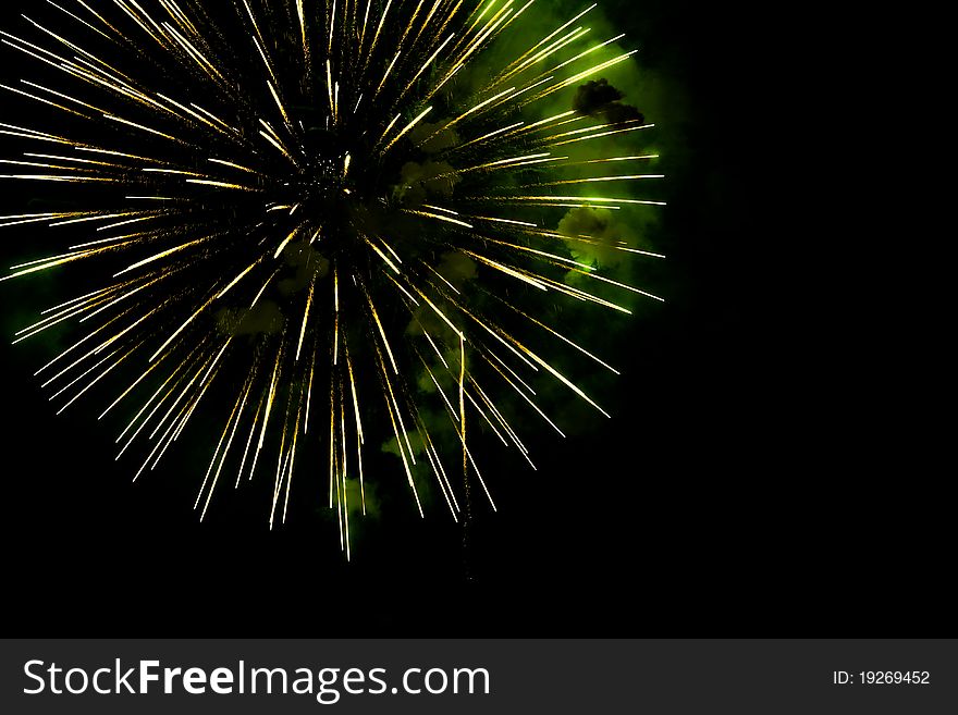 A burst of golden- green fireworks against a night sky. A burst of golden- green fireworks against a night sky.