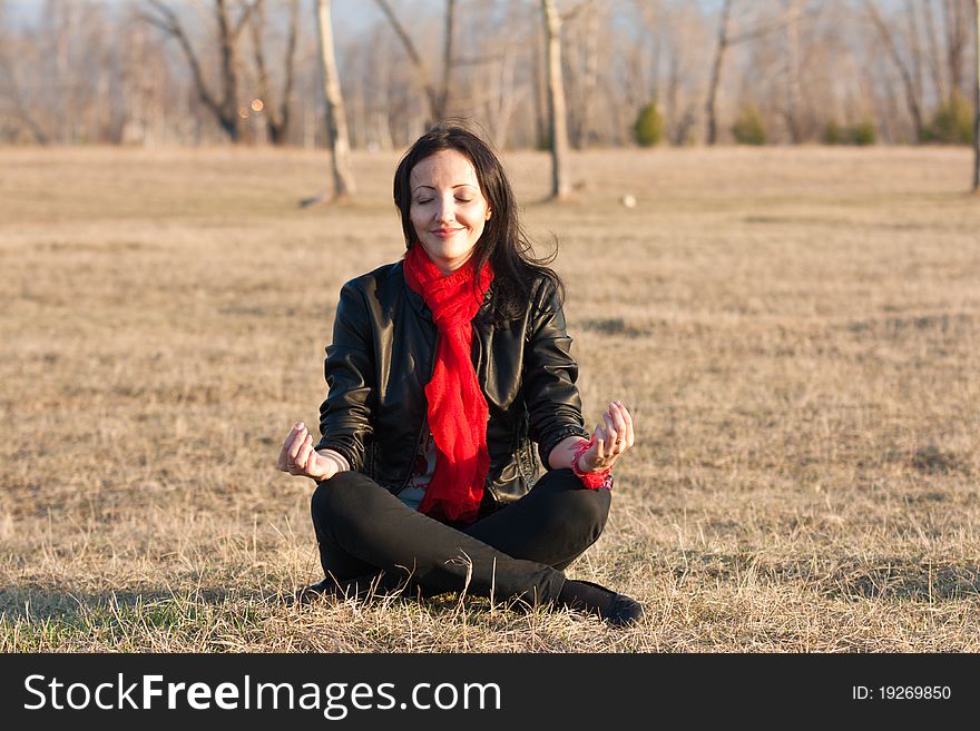 Girl meditates on a grass