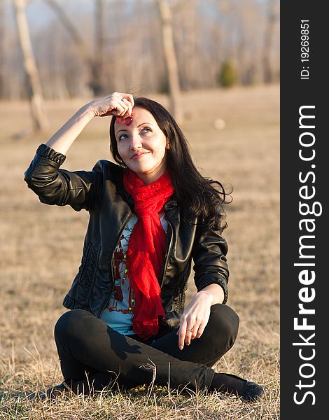 The woman sitting on a grass dreams in the open air