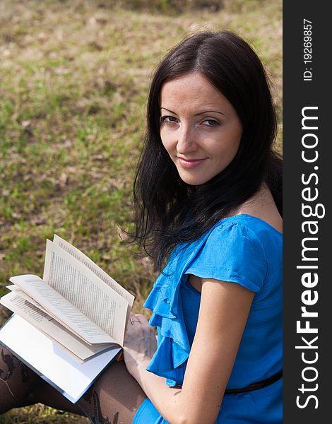 Girl reading book in spring park  in the open air