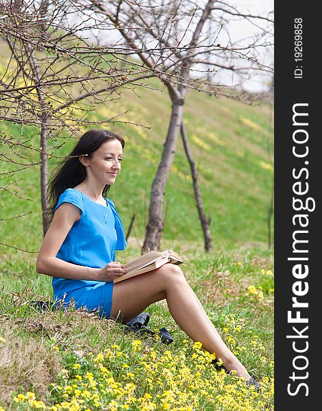 Girl reading book in spring park