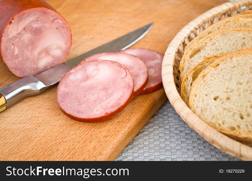 Sausage, bread in a basket and knife
