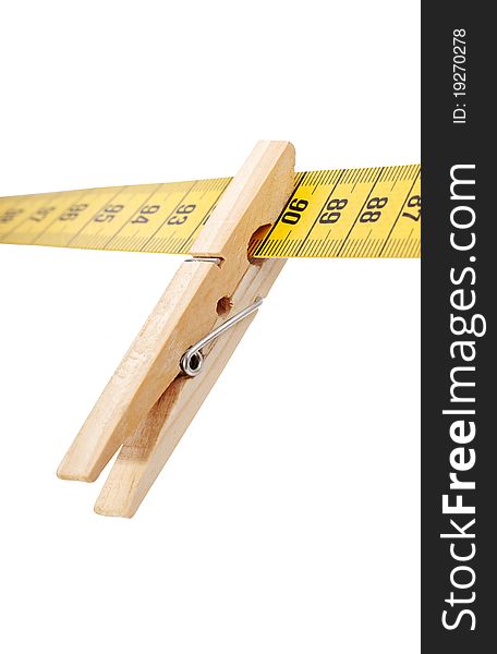 Clothespin and measuring tape isolated on a white surface. Clothespin and measuring tape isolated on a white surface.