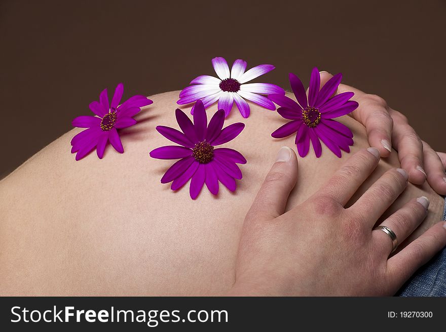 A pregnant woman with blossoms on her belly