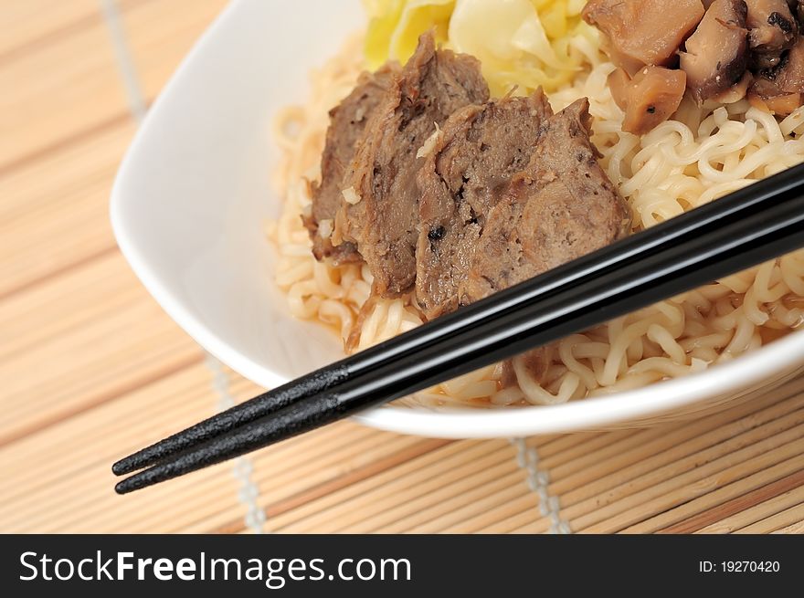 Asian style meat noodles in white bowl.