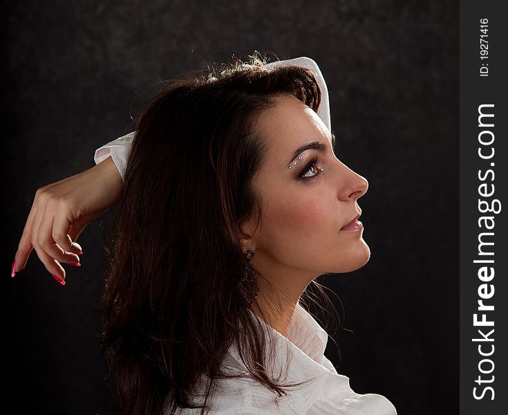 Portrait of an attractive woman in a white blouse on a black background