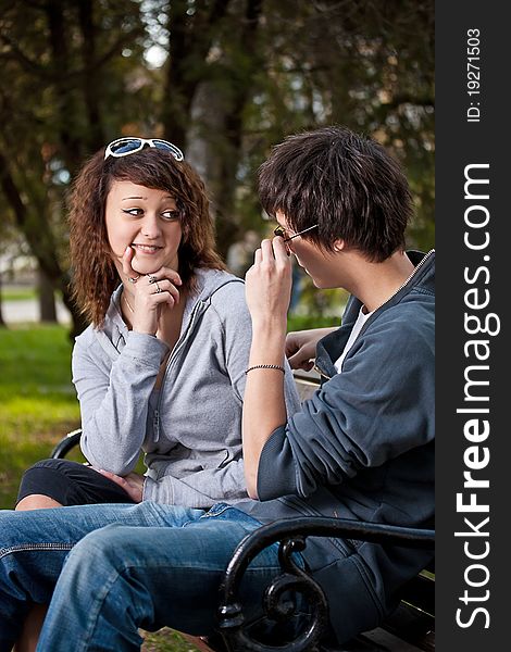 Attractive couple sitting on bench in the park