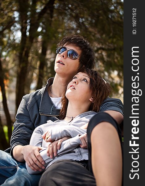 Attractive couple sitting on bench in the park