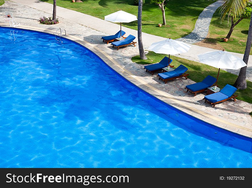 Chaise longue and umbrella at poolside. Chaise longue and umbrella at poolside