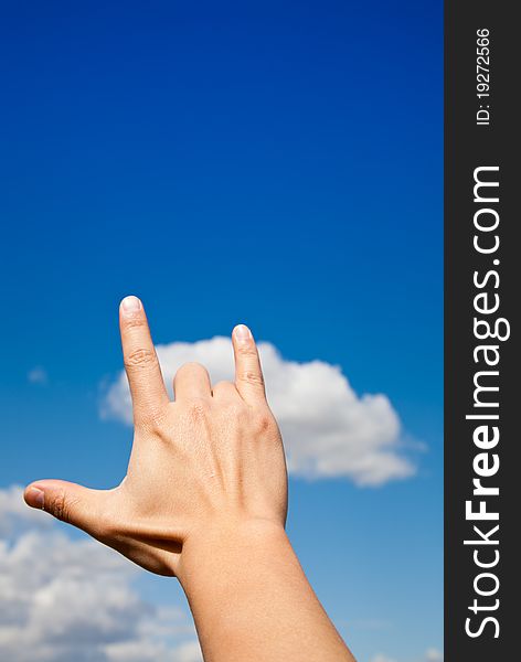 Hand Gesture - I love you against blue sky.