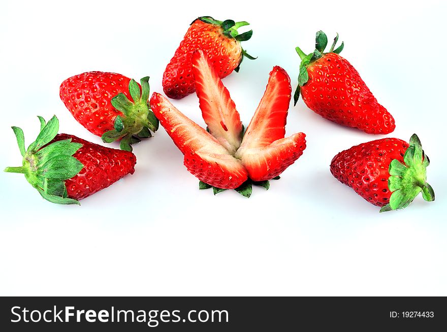 Sliced ​​strawberries and a number of five pieces lying on a white plate. Sliced ​​strawberries and a number of five pieces lying on a white plate