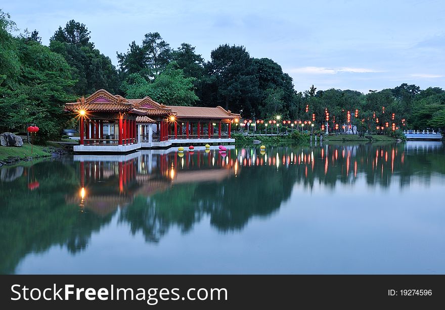 Chinese park at dusk lighted up with red lanterns.