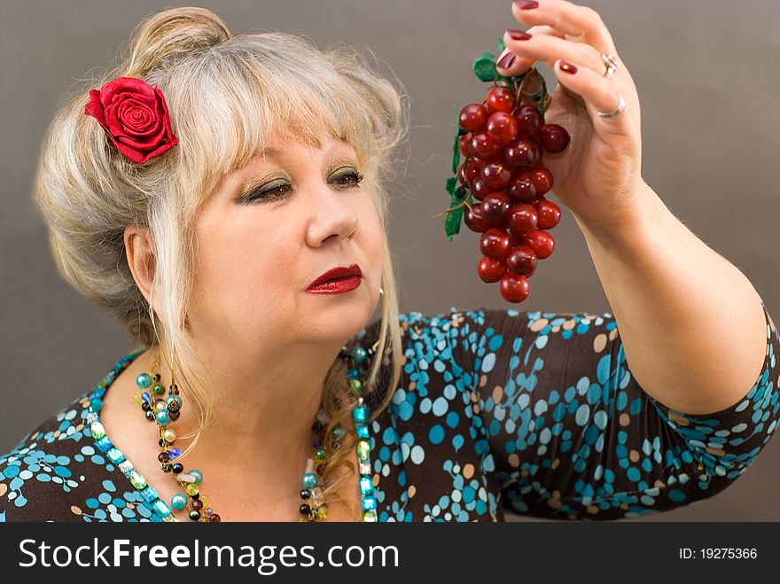 Portrait of a beautiful middle-aged women with red grape