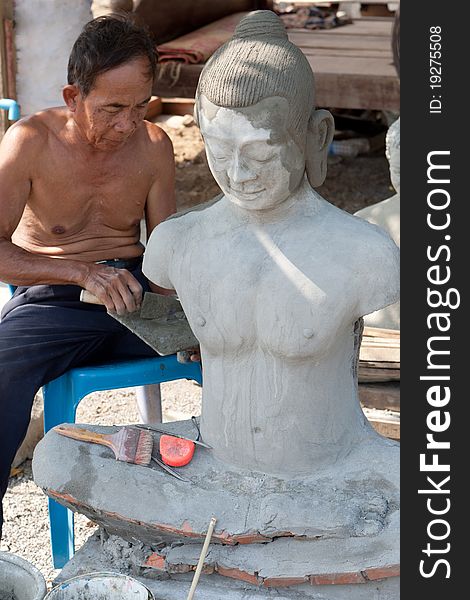 Restore buddhist figure, old Asian man with his craft