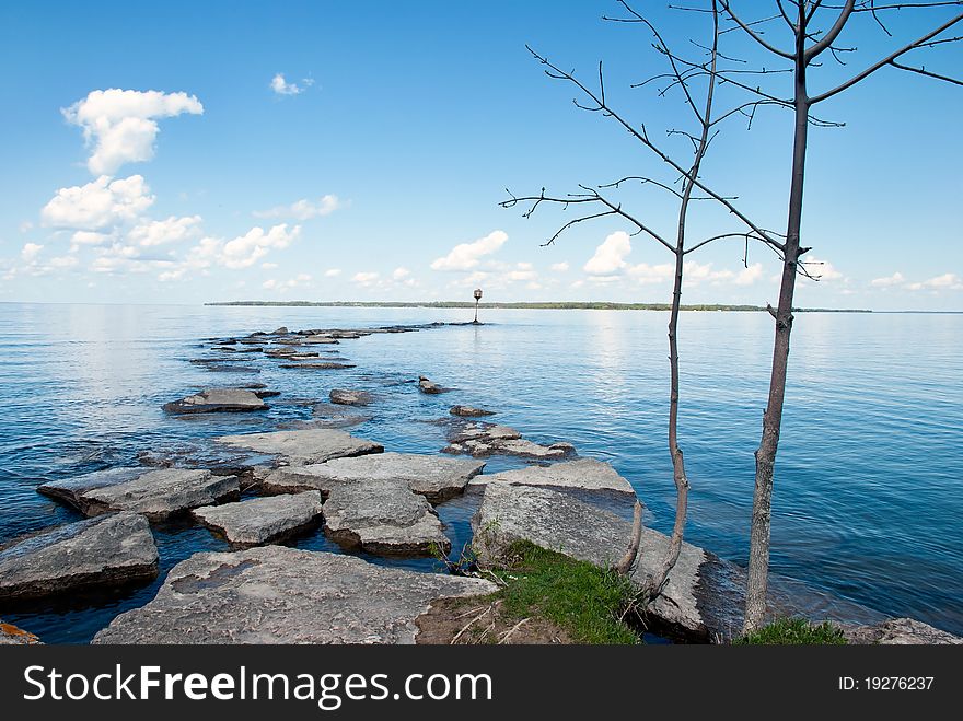 A lakeshore view. A sandspit going to horizon