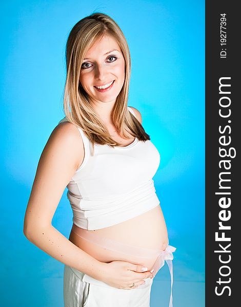 Pregnant blond woman on blue background