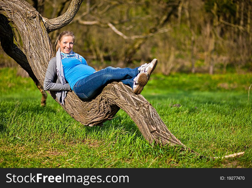 Pregnant woman outdoor in park at spring time