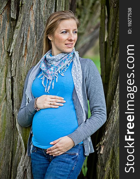 Pregnant woman outdoor in park at spring time