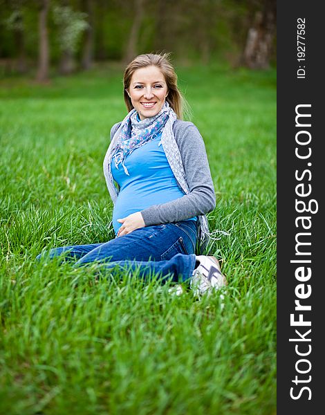 Pregnant woman outdoor in park at spring time