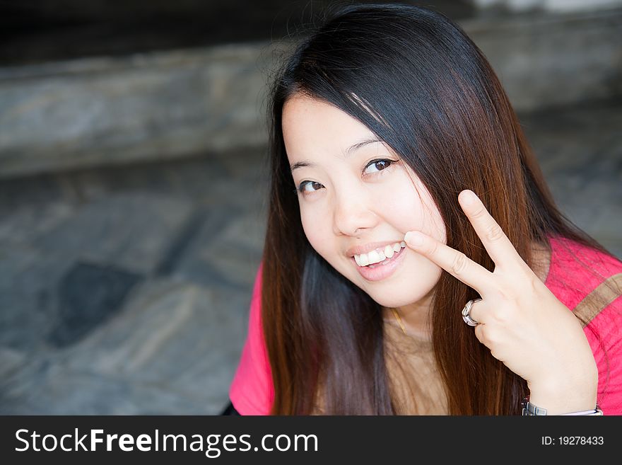 Asian women showing two fingers and smiling for confidence