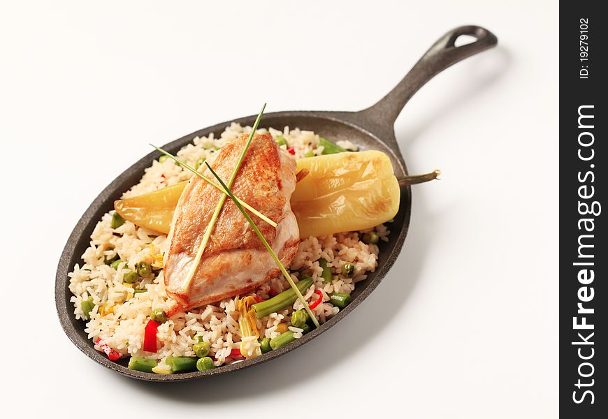 Fried rice and roasted chicken breast on a skillet. Fried rice and roasted chicken breast on a skillet