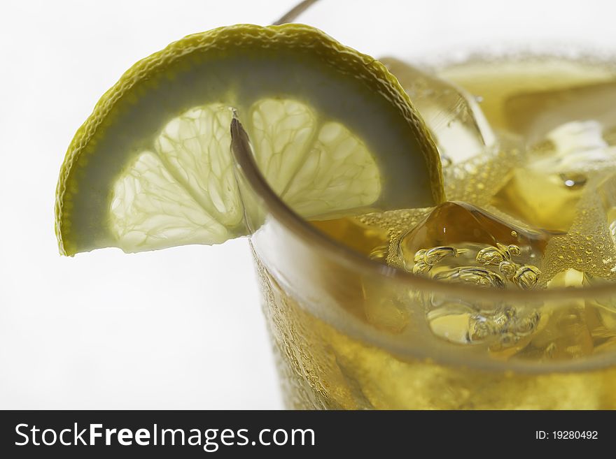 A glass of ice tea with lemon slice isolated on white background. Shallow depth of field