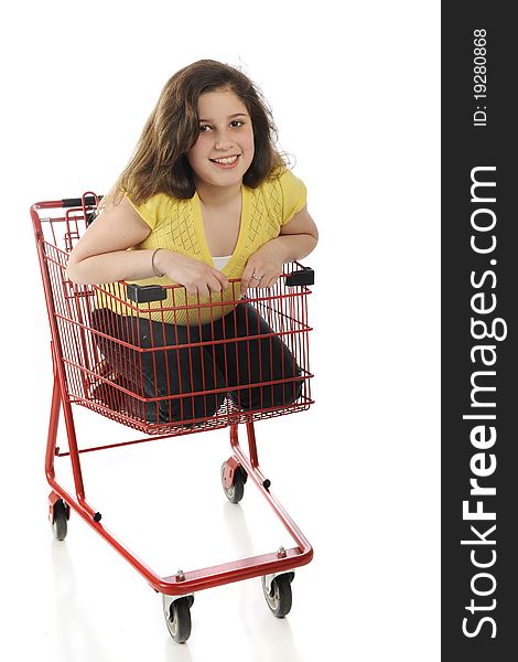 An attractive tween girl riding inside a bright red shopping cart. Isolated on white. An attractive tween girl riding inside a bright red shopping cart. Isolated on white.