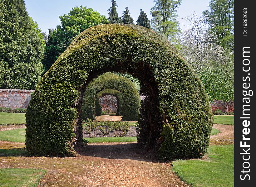 An English Formal Walled garden with path through a row of Arches. An English Formal Walled garden with path through a row of Arches