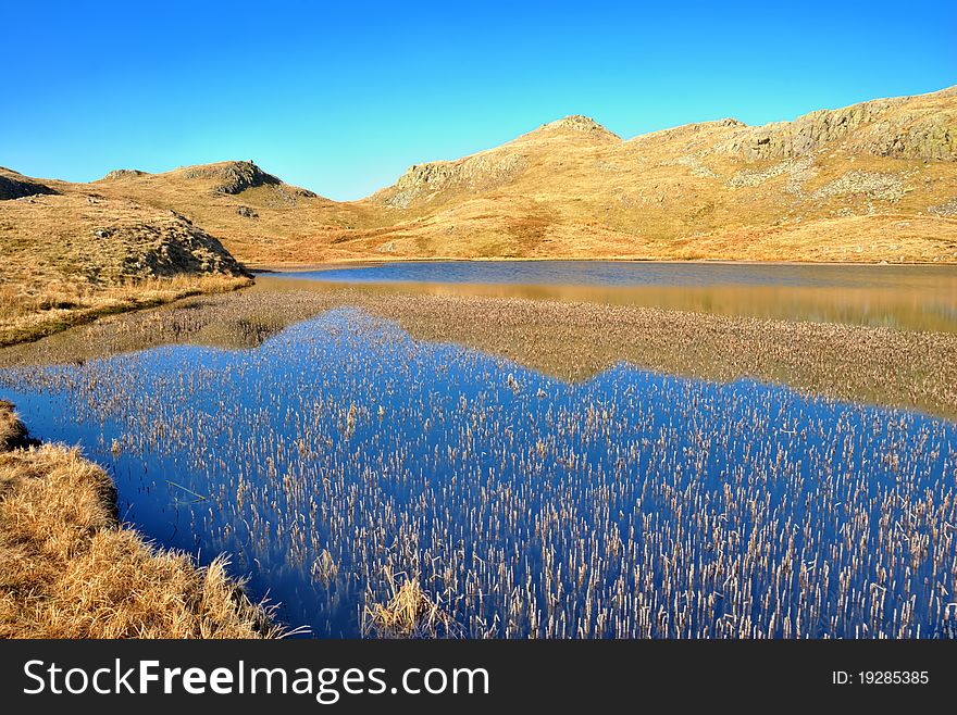 A deep blue mountain lake called Tarn at Leaves  in the English Lake District National Park