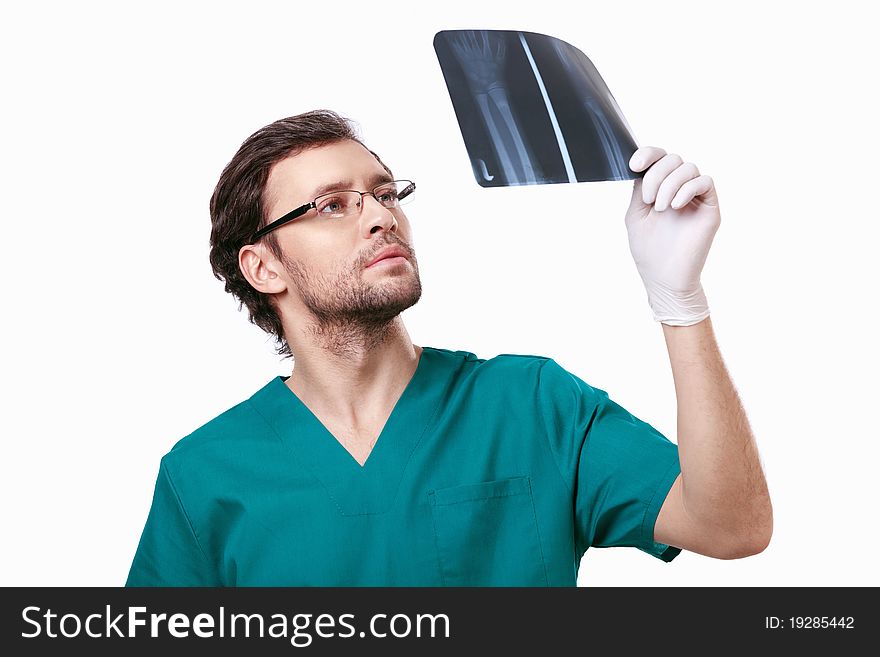 A young surgeon gloves considering X-ray. A young surgeon gloves considering X-ray