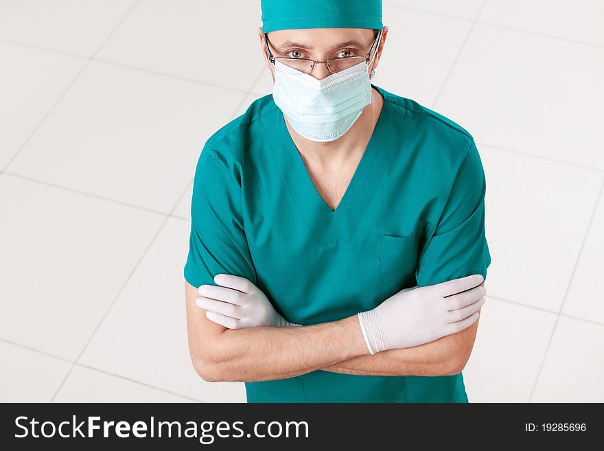 Surgeon in mask and gloves indoors. Surgeon in mask and gloves indoors