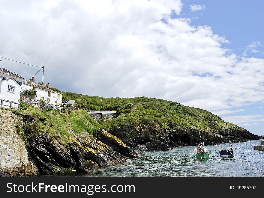 The Peaceful Cornish Harbour of Portloe with Fishing Boats under a blue sky. The Peaceful Cornish Harbour of Portloe with Fishing Boats under a blue sky