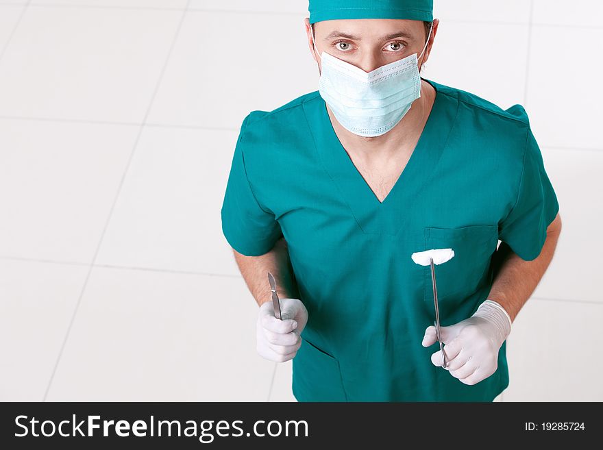 Surgeon in mask and gloves with the tools. Surgeon in mask and gloves with the tools