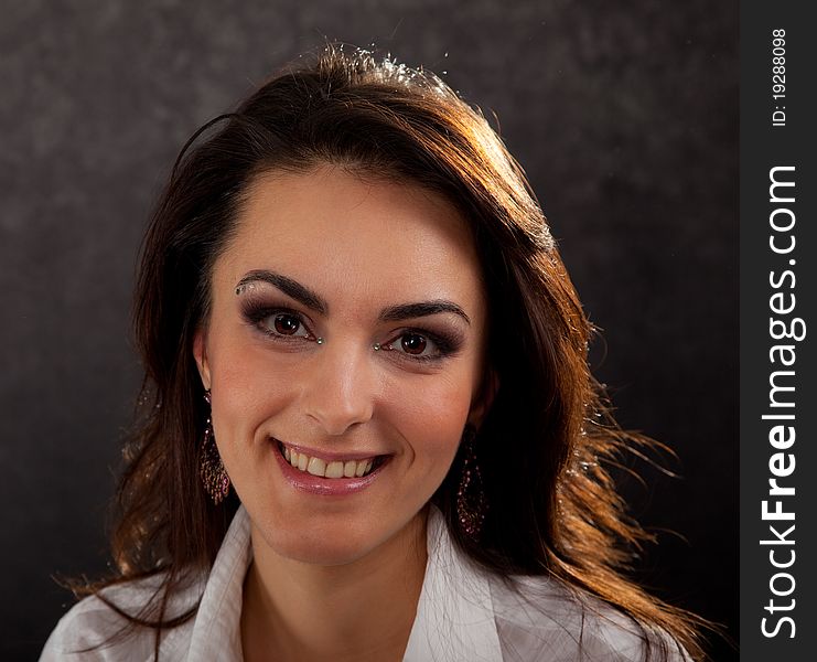 Portrait of an attractive woman in a white blouse on a black background