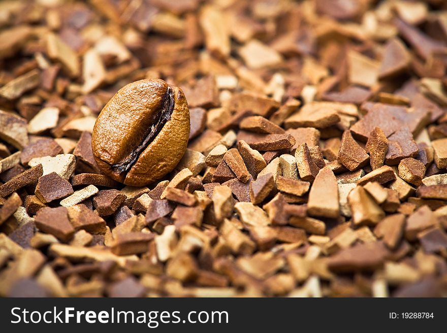 Closeup of a coffee bean and soluble coffee