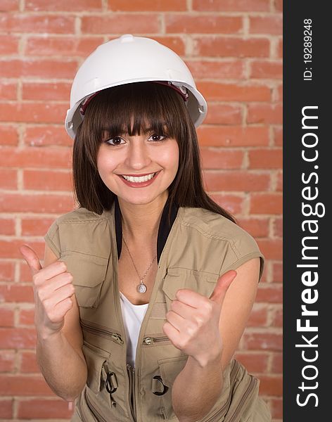 Pretty girl in a helmet against a red wall