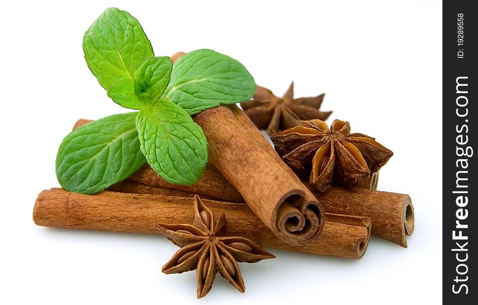 Sticks of cinnamon with mint and anise on a white background. Sticks of cinnamon with mint and anise on a white background