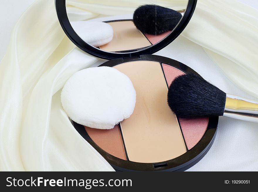 Makeup brushes and blush on white background