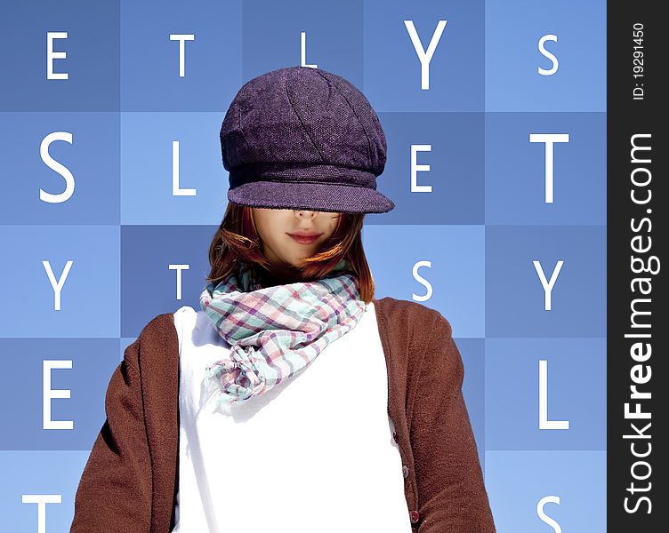 Portrait of red-haired girl with scarf and purple cap on blue background with words.