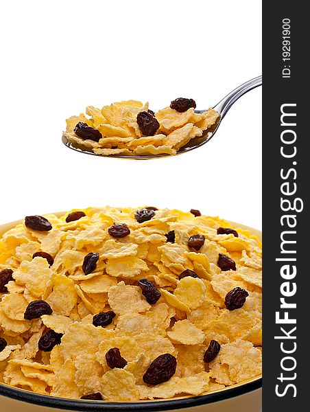 Corn flakes with raisins and spoon over the bowl. Corn flakes with raisins and spoon over the bowl.