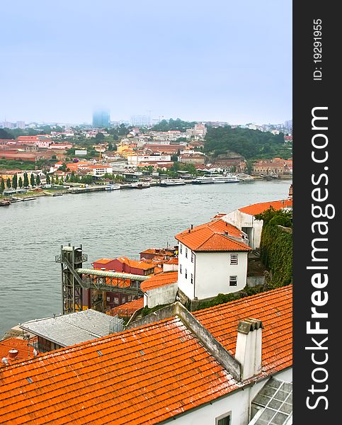 Beautiful view of Porto in fog with Douro river in center, with classic red tile roofs in Ribeira district in Porto, Portugal. Beautiful view of Porto in fog with Douro river in center, with classic red tile roofs in Ribeira district in Porto, Portugal