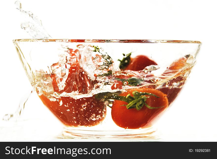 Red tomatoes in a plate with water on the white isolated background