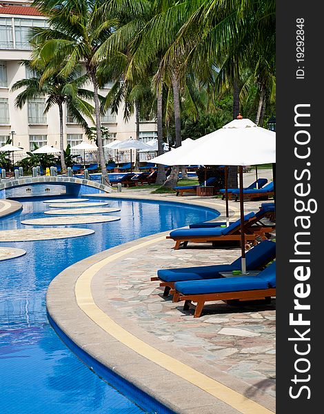 Resort poolside with recliners and sunshades. Resort poolside with recliners and sunshades.