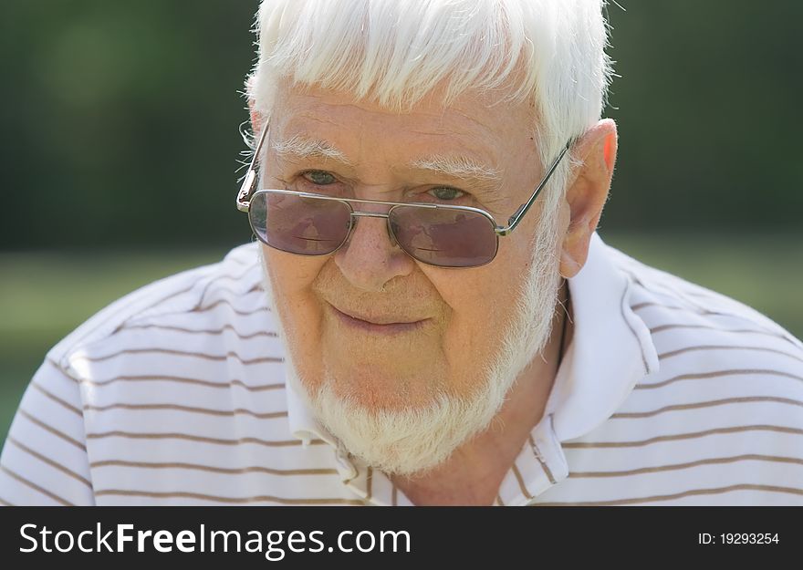 Old man wearing glasses outside during the day. Old man wearing glasses outside during the day