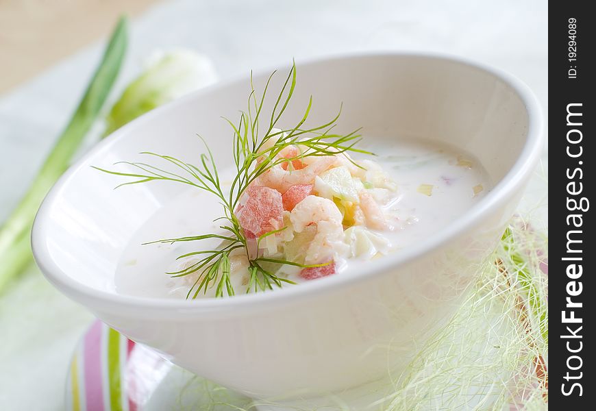 A bowl of cold soup with vegetables and shrimp