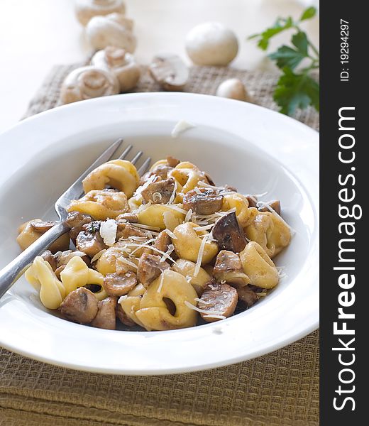 Tortellini with mushrooms sauce and cheese, selective focus