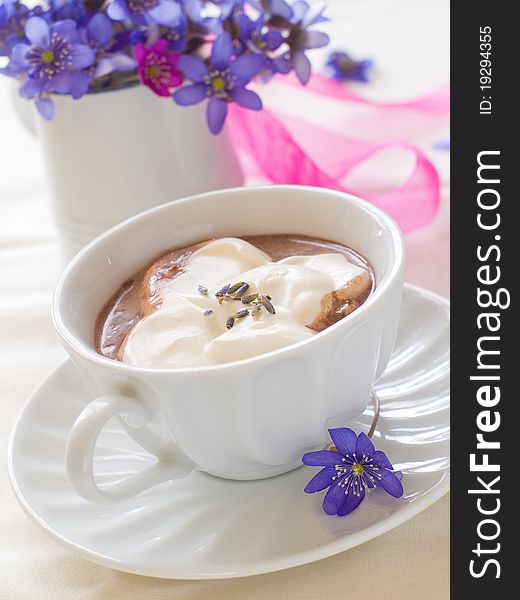 A cup of morning drink with whipped cream and lavender