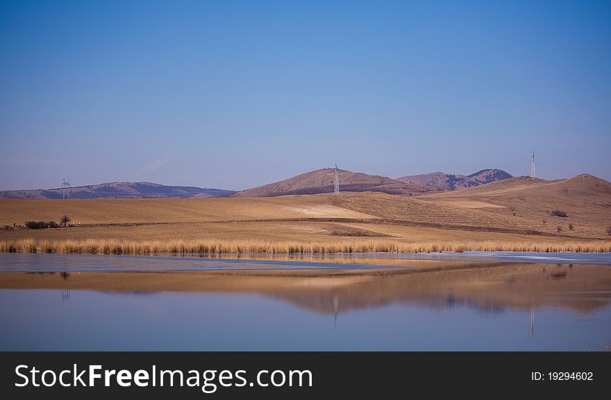 Spring landscape of Horia lake and Macin Mountains in the distance, in Dobrogea region of Romania.